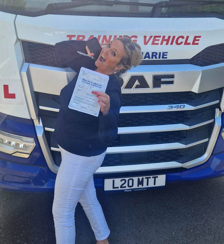 Deborah celebrating after passing her Category CE 3b test at MT Training Gloucestershire