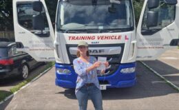 Amber celebrating her Cat C 3b test pass at MT Training Services Exeter, standing in front of a DAF rigid HGV training vehicle