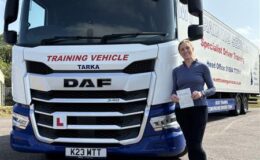 Carina celebrating her HGV CE 3b test pass at MT Training Services Bristol, standing next to a DAF articulated training lorry