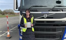 Laura celebrating passing her Cat C 3a HGV test at MT Training Services Wetherby Training Centre in front of training vehicle